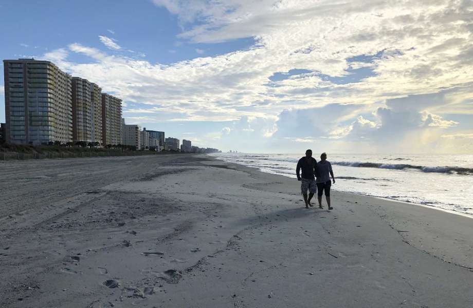 Chris and Nicole Roland walk down a beach in North Myrtle Beach, S.C. on Wednesday, Sept. 12, 2018. The couple boarded up their uncle's condominium and are leaving soon as Hurricane Florence approaches. Photo: Jeffery Collins, AP / Copyright 2018 The Associated Press. All rights reserved.