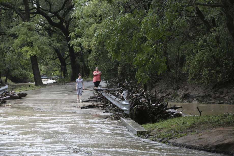 Grey Forest residents photograph debris at low water crossing, Sunday, Sept. 9, 2018. All low water crossings in Grey Forest were closed due to flooding Sunday morning. At the height of the storm, the main road leading into town, Scenic Loop Road, was closed for several hours. Photo: JERRY LARA, San Antonio Express-News / © 2018 San Antonio Express-News