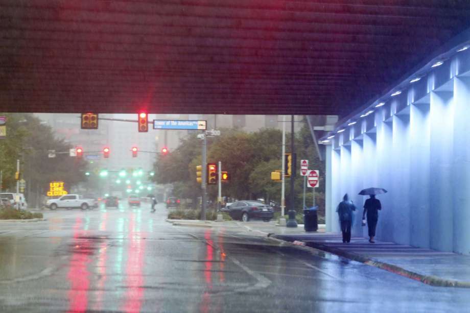 As rains falls, pedestrians walk under the East Commerce Street/IH-37 overpass, Sunday, Sept. 9, 2018. Heavy rainfall caused over 70 road closures in the area. Photo: JERRY LARA, San Antonio Express-News / © 2018 San Antonio Express-News