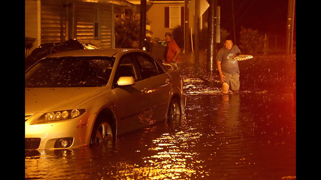 Men pack their belongings after evacuating their house after the Neuse River went over its banks and flooded their street during Hurricane Florence September 13, 2018 in New Bern, North Carolina. (Photo by Chip Somodevilla/Getty Images)