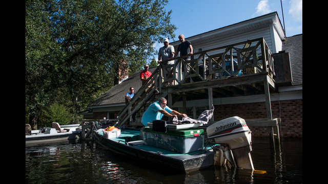 People use boats to rescue valuables from a home inundated by floodwaters caused by Hurricane Florence near the Waccamaw River. Floodwaters are expected to continue to rise in Conway over the next two days. (Photo by Sean Rayford/Getty Images)