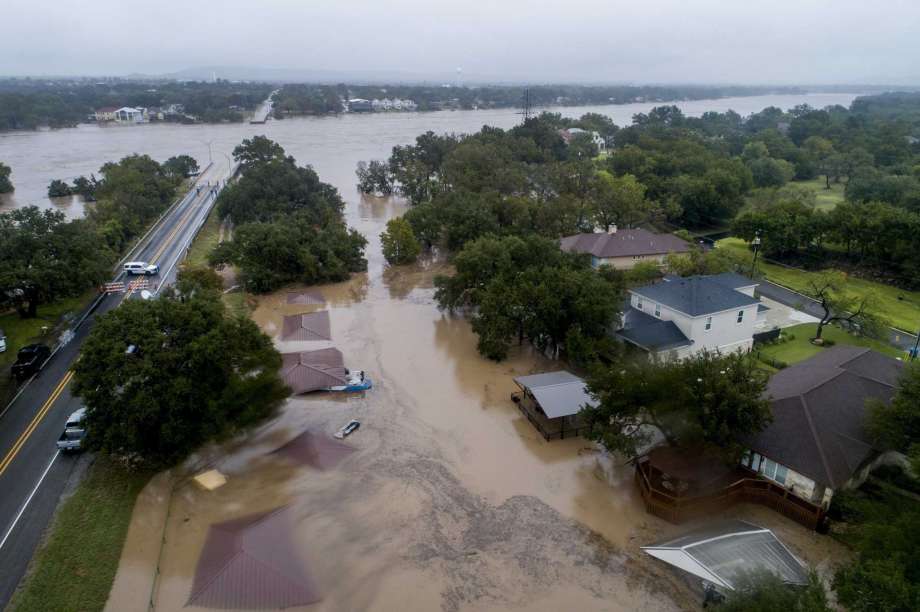 The Llano River overflows its banks into neighboring property as the swollen river flows between the washed out Ranch Road 2900 bridge, background, Tuesday, Oct. 16, 2018, in Kingsland, Texas. (Jay Janner/Austin American-Statesman via AP) Photo: Jay Janner, Associated Press / Austin American-Statesman
