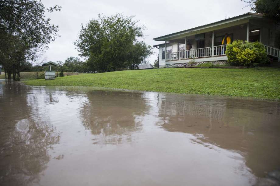 Joe Mercer and his friend Tonya Grace watch weather reports from their porch as the rising waters from the Colorado River floods their property on Tuesday Oct. 16, 2018, in Marble Falls, Texas. Mercer says they will evacuate their home if the nearby creek gets higher. (Amanda Voisard/Austin American-Statesman via AP) Photo: Amanda Voisard, AP / Austin American-Statesman