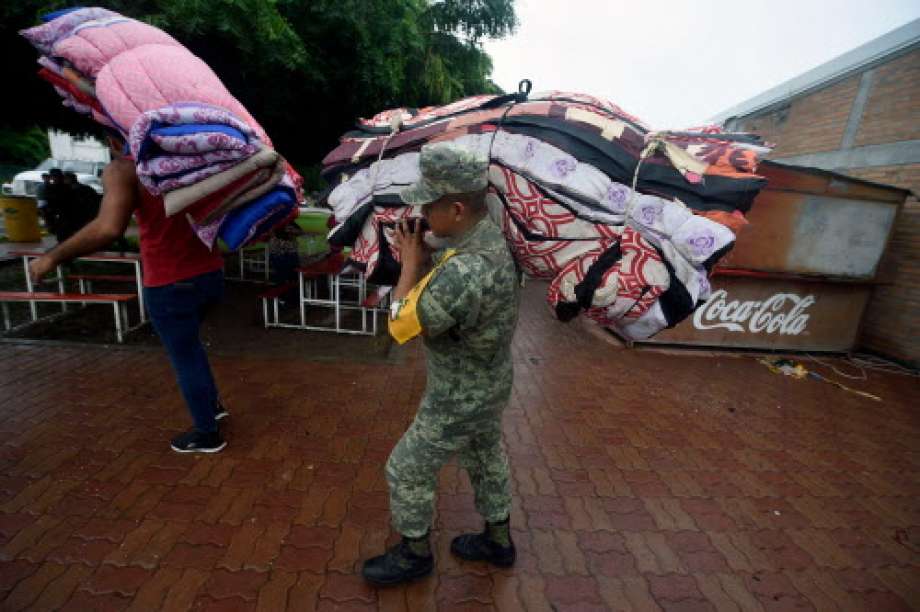 A soldier carries blankets at an improvised shelter in Escuinapa, Sinaloa state, Mexico, on October 23, 2018, before the arrival of Hurricane Willa.  Photo: ALFREDO ESTRELLA, AFP/Getty Images / AFP or licensors