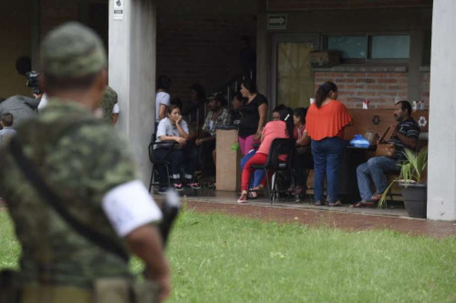 A soldier stands guard as people remain at an improvised shelter in Escuinapa, Sinaloa state, Mexico, on October 23, 2018, before the arrival of Hurricane Willa.  Photo: ALFREDO ESTRELLA, AFP/Getty Images / AFP or licensors