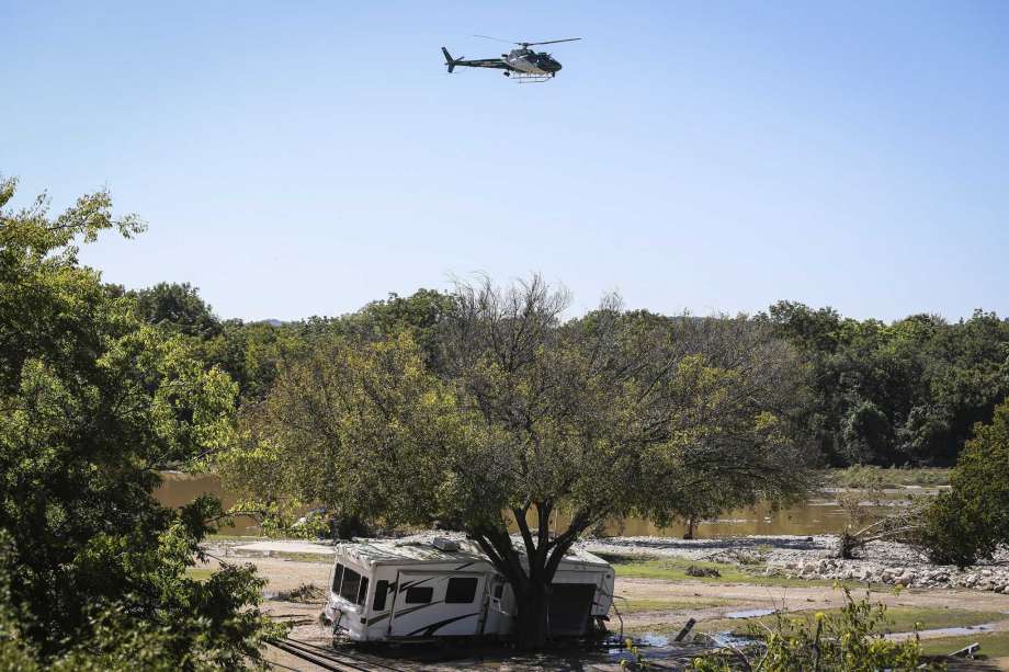 Search and rescue helicopter flies by the RV park hit in Monday's South Llano River flooding Wednesday, Oct. 10, 2018, in Junction, Texas. (Yfat Yossifor /The San Angelo Standard-Times via AP) Photo: Yfat Yossifor, AP / The San Angelo Standard-Times