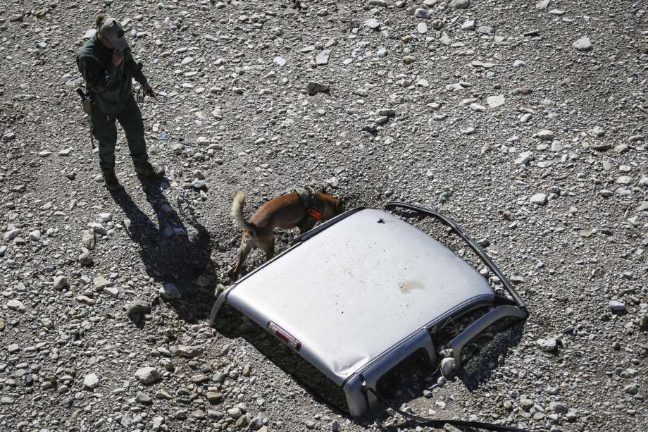 A search and rescue dog sniffs around a truck buried in the sand after South Llano River flooded Wednesday, Oct. 10, 2018, in Junction, Texas. (Yfat Yossifor /The San Angelo Standard-Times via AP) Photo: Yfat Yossifor, AP / The San Angelo Standard-Times