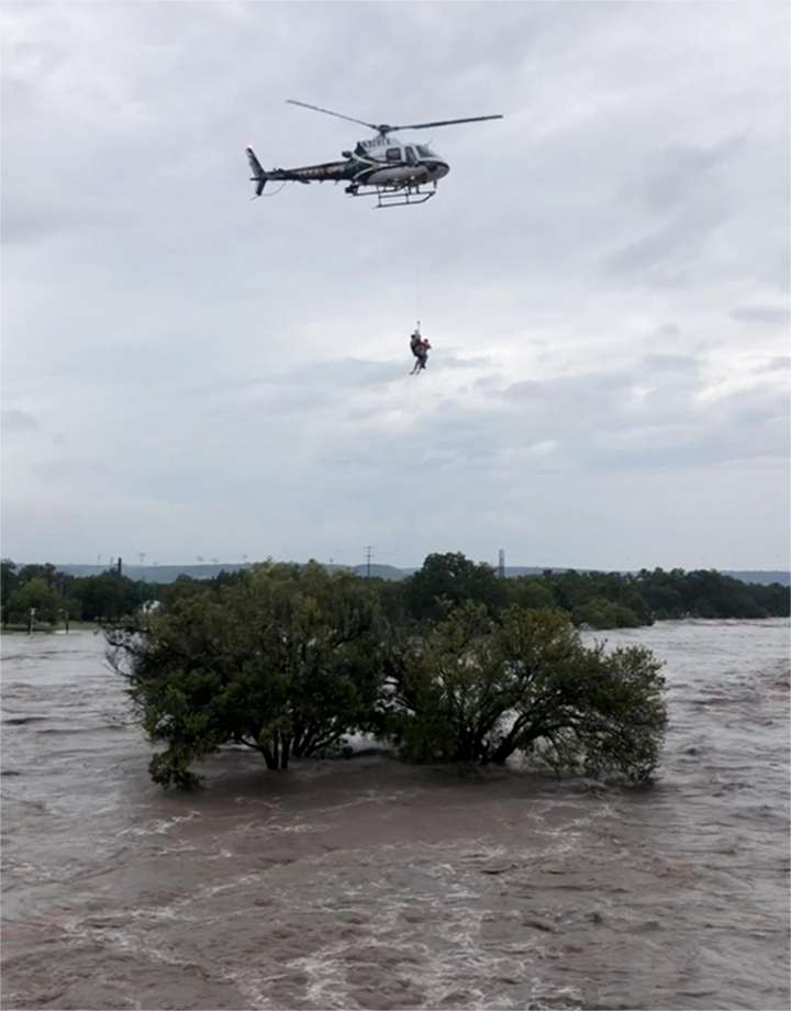 A Texas DPS helicopter crew extracts a person who sought refuge in a tree as the South Llano and Llano rivers near Junction flooded early Monday. The flooding caused temporary closure of a handful of Hill Country state parks. Photo: Texas Parks And Wildlife Department / Texas Parks and Wildlife department
