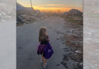 Little girl trick-or-treats among hurricane debris