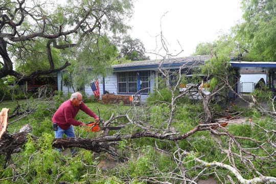 Rudy Rodriguez clears downed trees on West D Avenue in Kingsville on Friday, June 7, 2019, the morning after severe weather.