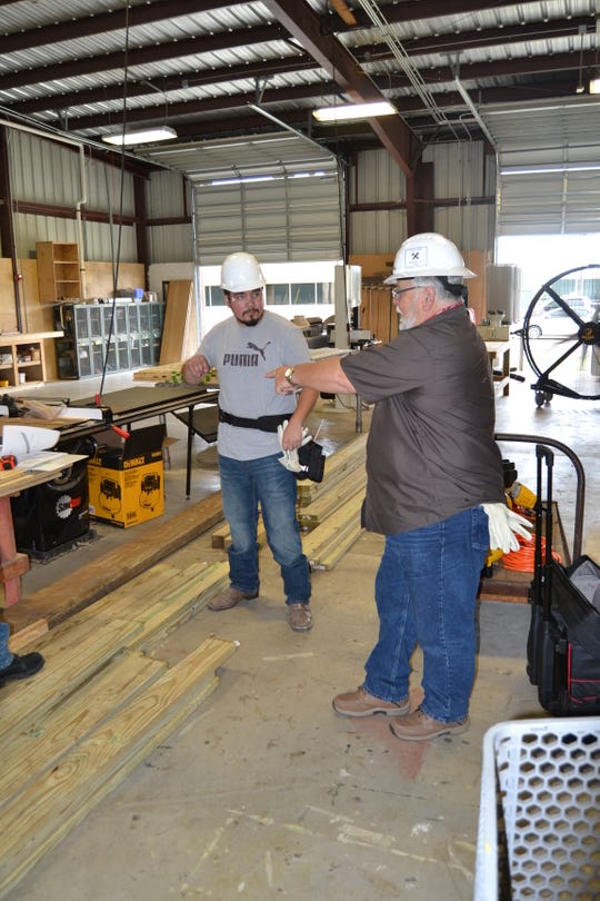 Alex Bayarena (right) instructs student Fernando Reyes on saw techniques during the Rebuild Texas Carpentry Skills Training program.
