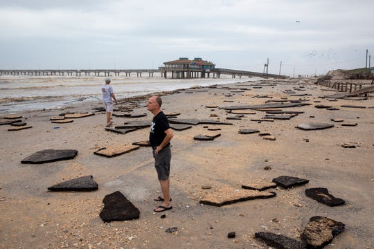 People walk along the beach near the damaged Bob Hall Pier the morning after Hurricane Hanna Sunday, July 26, 2020. 