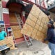 Cesar Reyes, right, carries a sheet of plywood to cut to size as he and Robert Aparicio, left, and Manuel Sepulveda, not pictured, install window coverings at Strand Brass and Christmas on the Strand, 2115 Strand St., in Galveston on Monday, Aug. 24, 2020. Ginger Herter, who manages the shop, was erring on the side of caution boarding up the storefront as she waits to see what path Tropical Storm Laura will take as it heads toward the Texas and Louisiana coasts. "I'd rather do this and have to take them down rather than scramble to get them up later in the week," she said.