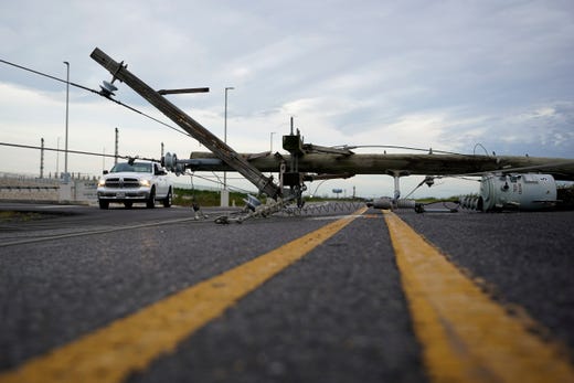 Down power lines stretch across a road in the aftermath of Hurricane Laura Thursday, Aug. 27, 2020, in Sabine Pass, Texas. (AP Photo/Eric Gay)