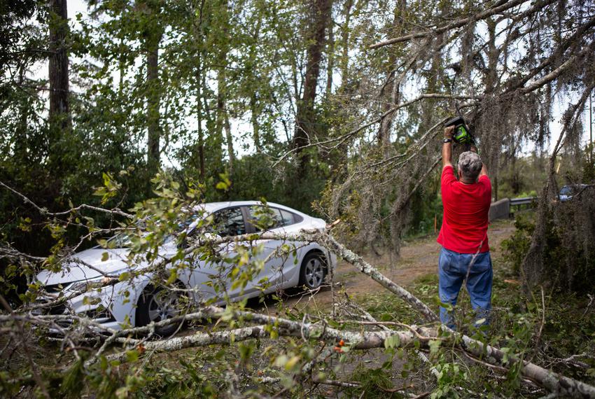 Robert Sepulvado clears debris off the road caused from Hurricane Laura in Orange on Aug. 27, 2020.