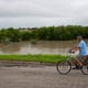 A man on a bike rides past a elevated La Volla creak next to the Las Colonias neighborhood on Saturday, Sept. 15, 2018. 