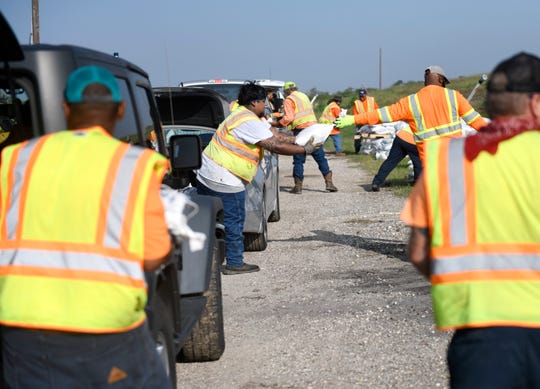 Residents pick up free sandbags ahead of Tropical Storm Beta, Saturday, Sept. 19, 2020, at J.C. Elliot Transfer Station and Collection Center. Due to COVID-19 concerns, drivers and passengers were asked to wear a mask and not exit their vehicle during loading. 