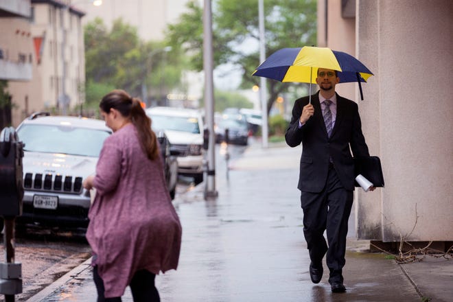People walk in the rain in uptown on Friday, May 3, 2019. A system of severe thunderstorms were forecast to move over South Texas bringing high winds and potential hail.