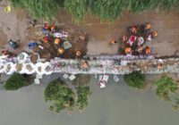 Flooding sends bus into river in China; 120,000 evacuated