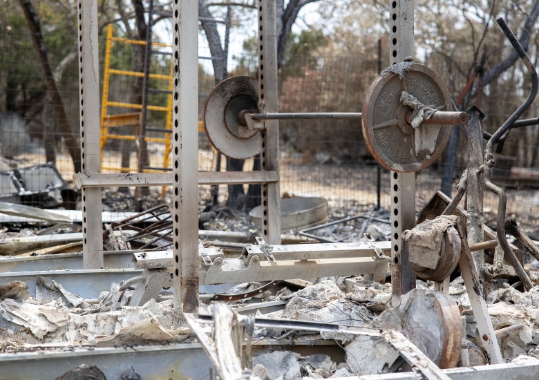 A barbel rack remains standing among charred equipment and ashes after the Das Goat fire consumed over 1,000 acres of land in Medina County on Tuesday.