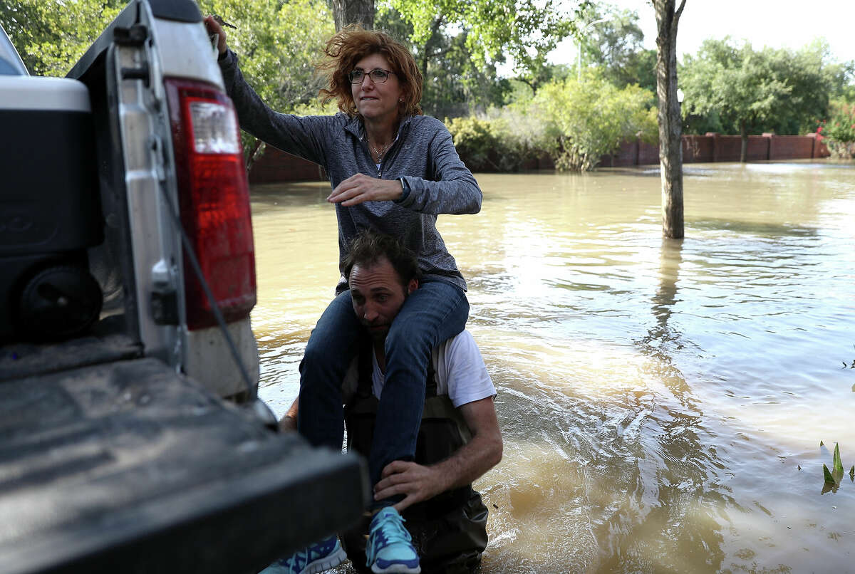 Chris Ginter carried Mila Milo on his shoulders through floodwaters as she visits her parents flooded home on September 6, 2017 in Houston, Texas. Houston resident Chris Ginter took local residents to their flooded homes in his monster truck, which can drive through waters up to four feet deep.