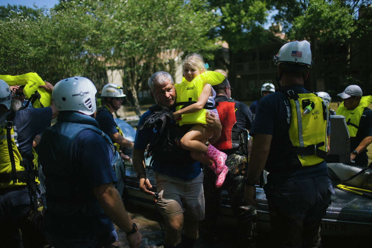 Ken Jacobs the operations director at Bayou City Adventures carries five-year old Astrid Galperin from a rescue boat on Thursday, August 31, 2017. Andrew Brenneise organized a flotilla of private boats via Facebook to help rescue hundreds of people in his west Houston neighborhood. John Taggart for The Washington Post via Getty Images