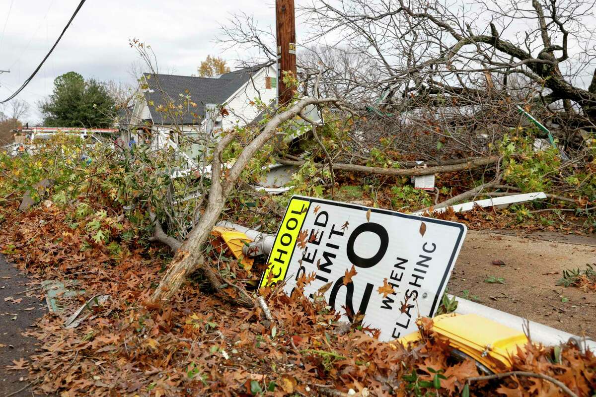 A school zone speed limit sign lays with downed trees along North Lucas Drive after a possible tornado in Grapevine, Texas, Tuesday, Dec. 13, 2022. (Elías Valverde II/The Dallas Morning News via AP)