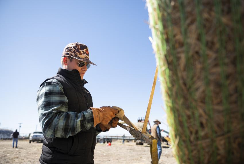 Pierson Sparks unloads hay at a donation site Friday, March. 1, 2024, in Borger, Texas.