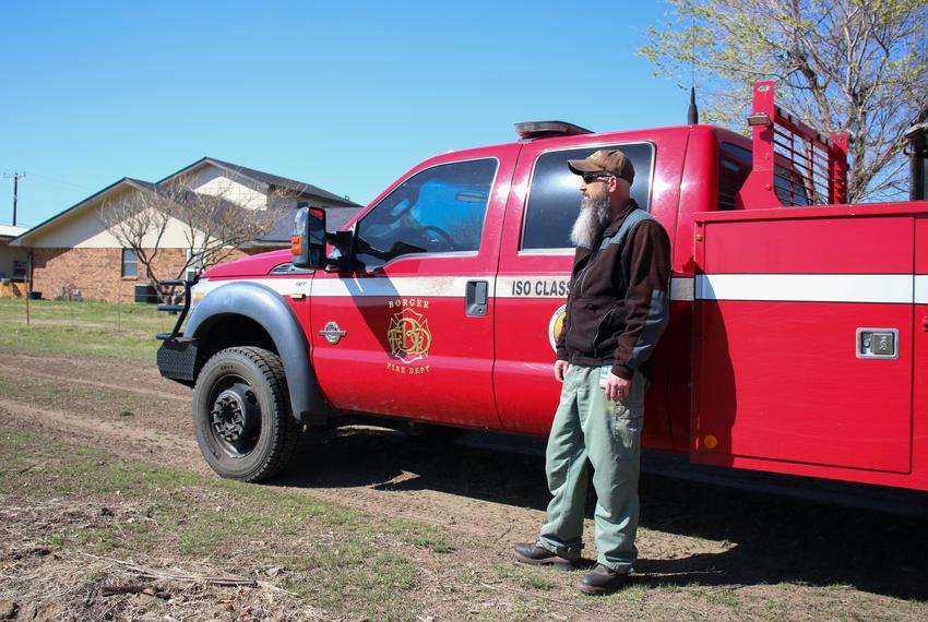 Archie Stone, wildland coordinator for the Borger Fire Department, stands by his truck parked near a neighborhood adjacent to the site of a prescribed burn.