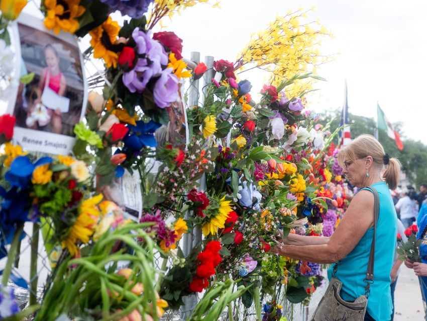 Community members add flowers to a memorial honoring victims of the flood in Kerrville on Wednesday July 9, 2025.